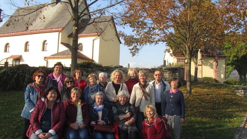 Společná fotografie účastníků u rtyňského kostela sv. Jana Křtitele